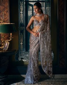 This steel grey net saree features sequin and crystal embroidery. The saree border is scalloped and is paired with crystal embedded blouse.From Seema Gujral's Kashish collection DELIVERY TIMEPlease allow 8-12 weeks for your outfit to arrive. FABRIC DETAILSNet Professional cleaning only. Sequin Border Saree, Blouse Pattern For Net Saree, Grey Net Saree, Crystal Saree, Seema Gujral, Sequin Saree, Grey Saree, Bollywood Dress, Crystal Embroidery