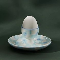 an egg sitting on top of a blue and white saucer