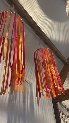 several streamers hanging from the ceiling in a room with white walls and wooden beams