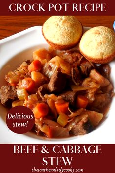 beef and cabbage stew in a white bowl with two muffins on the side