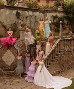 a group of women standing next to each other on top of a stone staircase in front of a building