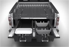 the back end of a silver truck with its cargo compartment open and dishes in it