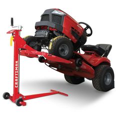 a red lawn mower sitting on top of a lift