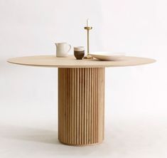 a wooden table with two cups and saucers sitting on it's pedestals