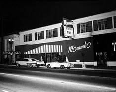 cars are parked in front of a building at night