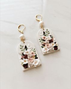 two pairs of earrings with flowers painted on them