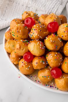 a white plate filled with donuts covered in sprinkles