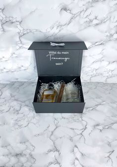 Jetzt geht es an die Planung der Hochzeit! Mit dieser tollen Geschenkbox kannst Du deinen Trauzeugen fragen.Die personalisierte Box kann mit allem möglichen befüllt werden, zum Beispiel mit Socken, Alkohol, Flachmann, Fotos uvm..Produktinformation/Material: - Größe der personalisierten Box; 23x17x10cm- Verschluss: mit Magnetklappe auf der Vorderseite mit 2 Magneten- schwarz matt (Cellophanieren, innen und außen) - 1,8 mm Pappe (sehr stabil)- Schleife weiß Maid Of Honor