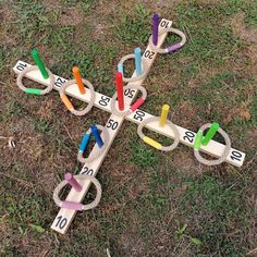 a cross made out of wooden pegs with numbers on them sitting in the grass