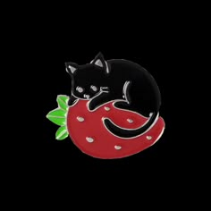 a black cat laying on top of a red object with green leaves around it's neck