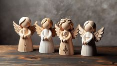 three wooden angel figurines sitting on top of a table next to each other