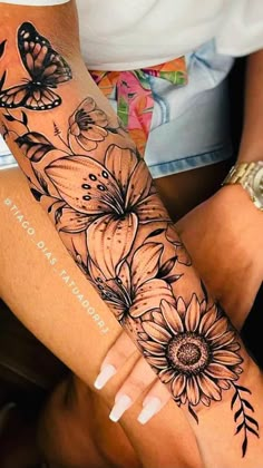 a woman's arm with flowers and butterflies on it