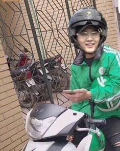 a man in green jacket sitting on motorcycle next to wall with bikes behind him and text that reads x young repartior no existee