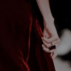 a close up of a person holding the hand of another person wearing a red dress