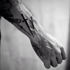 black and white photo of a man's arm with two crosses on it,