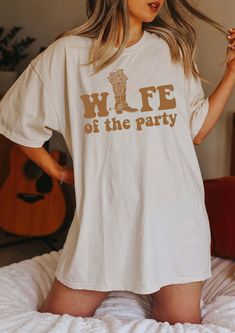 a woman standing on top of a bed wearing a t - shirt that says the party