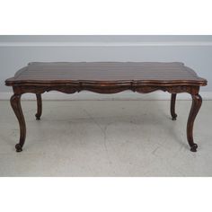 an antique coffee table with carved legs and wood grained top, in the style of louis ii