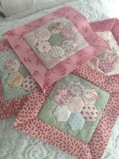 several patchwork quilts laid out on a bed