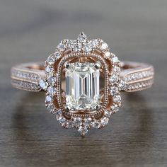 a fancy engagement ring with an emerald center surrounded by white and rose gold pave