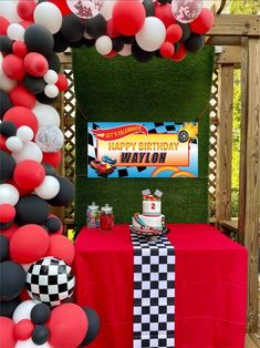 a red table topped with a cake and balloons