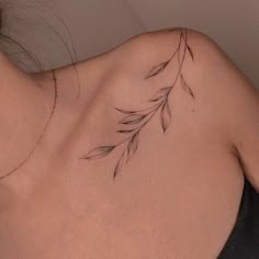 a woman's back with a branch tattoo on her left shoulder and right arm