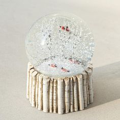 a snow globe sitting on top of a tree stump in the middle of a room