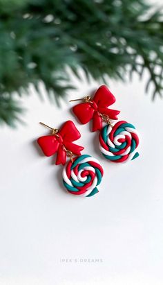 two red and blue earrings with bows on them