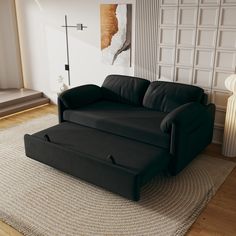 a black couch sitting on top of a rug