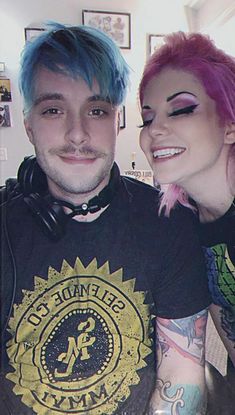 a man and woman with pink hair posing for the camera