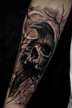 a black and grey tattoo with a skull and a raven on it's arm