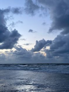 the sky is filled with clouds over the ocean