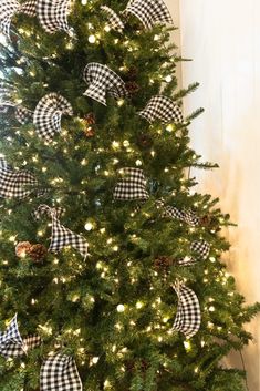 the christmas tree is decorated with black and white bows