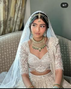 a woman in a bridal outfit sitting on a couch