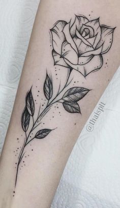 a black and white rose tattoo on the arm