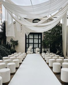 an outdoor ceremony with white flowers and draping