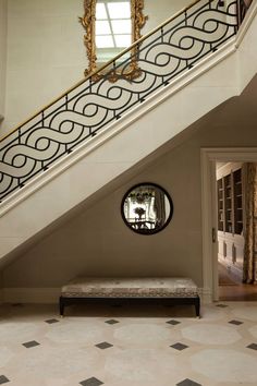 the stairs in this house are decorated with black and white designs, along with a gold framed mirror