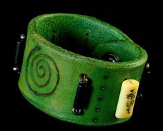 Leather cuff bracelet. Made from saddle leather dyed green. Burned circle of life design with antique Chinese beads and glass black beads. Burnished edges and snap closure. Hand made: size 7.5" wrist size. 1.5" wide. Will soften with age and wearing. Very comfortable. Will last a life time. Handmade Green Leather Bracelet, Leather Cuff Bracelet, Leather Dye, Saddle Leather, Leather Cuffs Bracelet, Circle Of Life, Life Time, Leather Cuffs, Life Design