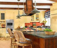 a kitchen with yellow cabinets and an island