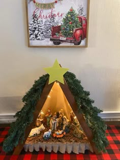 a nativity scene is displayed in front of a christmas tree with lights on it