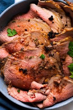 some meat is in a bowl with parsley on the side and garnished