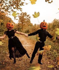 two people dressed up as jack - o'- lanterns holding hands