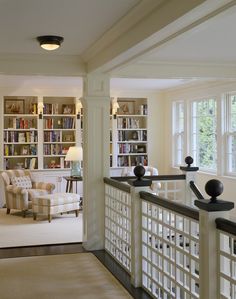 a living room filled with lots of furniture and bookshelves next to a window