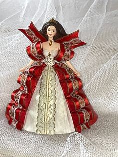 a red and white christmas ornament with a woman's dress on it