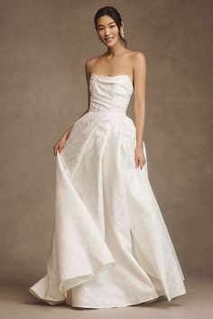 a woman in a white wedding dress posing for a photo with her hand on her hip