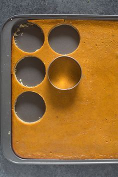 a baking pan filled with muffins on top of a gray counter next to a cupcake tin