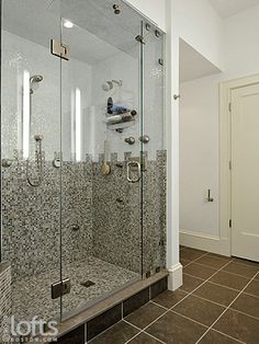 a walk in shower sitting inside of a bathroom next to a door and tiled floor