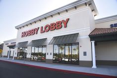 a hobby store with cars parked in front