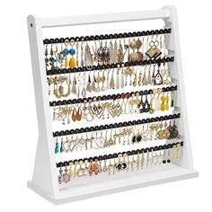 a white jewelry rack with lots of earrings on it