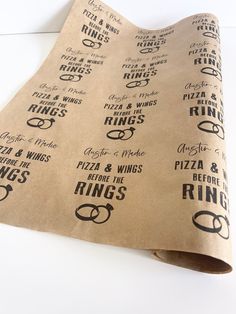 a brown paper bag with black lettering on it that says pizza and wings before the rings