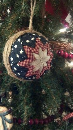 an ornament hanging from a christmas tree decorated with red, white and blue fabric